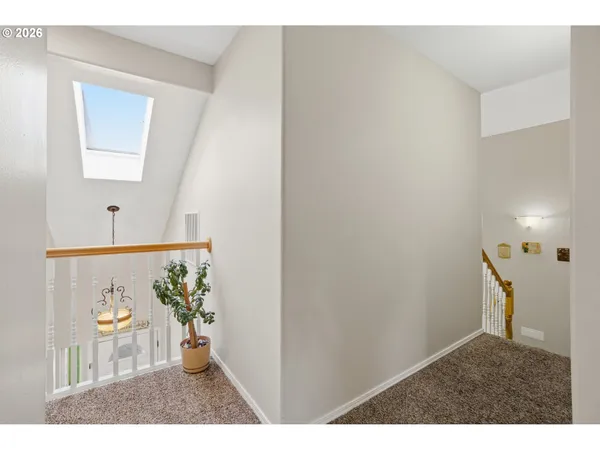 a view of a hallway with wooden floor and a living room