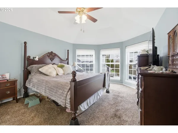 a spacious bedroom with a bed and wooden floor