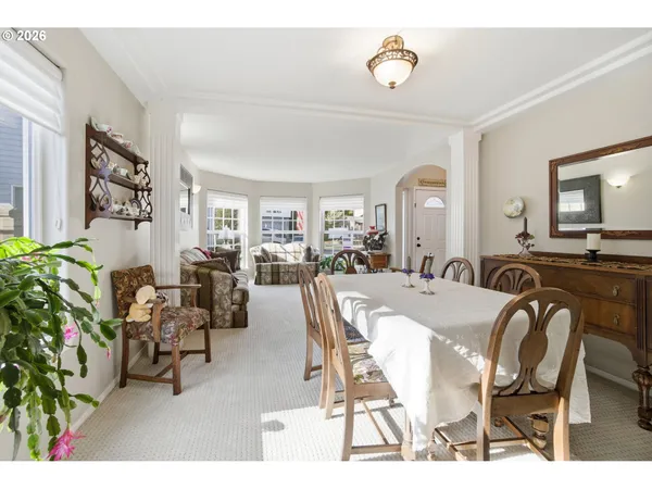 a view of a dining room and livingroom with furniture wooden floor and a rug