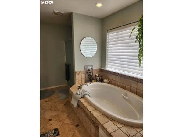 a bathroom with a tub sink and mirror