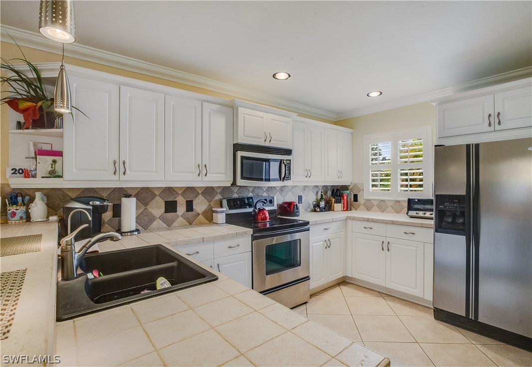 17373 Butler Road Fort Myers, FL 33967 - Photo 9 of 20 a kitchen with granite countertop a sink and white stainless steel appliances