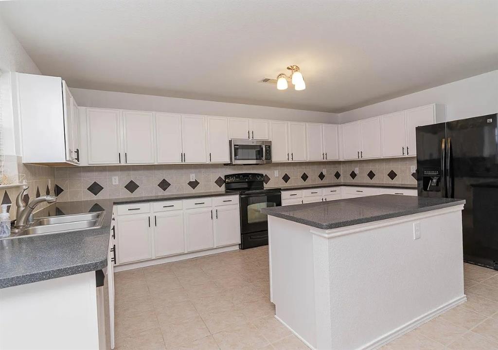 2743 Cold Water Trail Grand Prairie, TX 75052 - Photo 2 of 20 a kitchen with granite countertop a sink a counter top space stainless steel appliances and cabinets