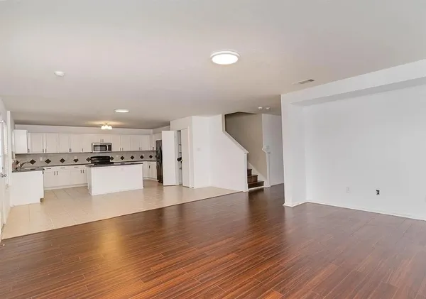a view of kitchen with a sink and dishwasher a oven with wooden floors