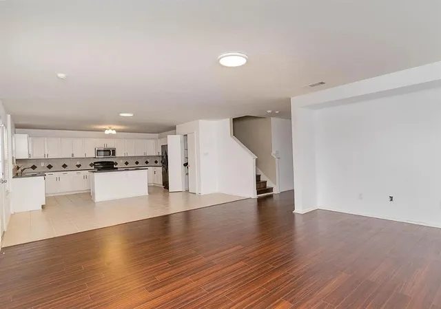 a view of kitchen with a sink and dishwasher a oven with wooden floors
