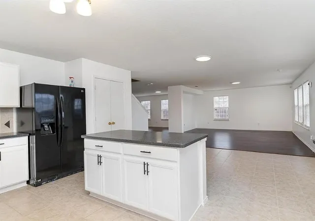 a kitchen with granite countertop a refrigerator and a sink