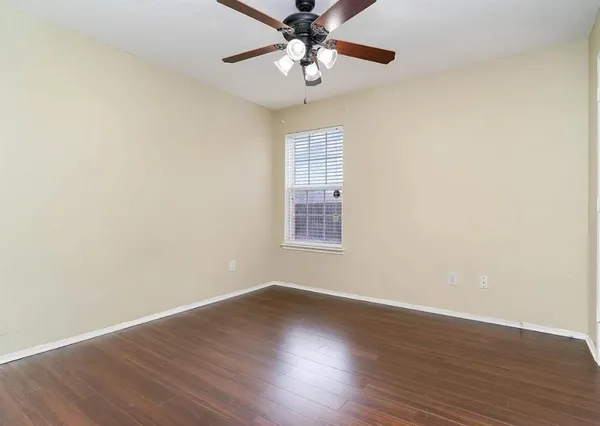 a view of wooden floor and chandelier fan in a room