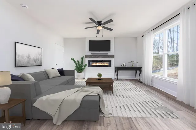 a living room with furniture a flat screen tv and a window
