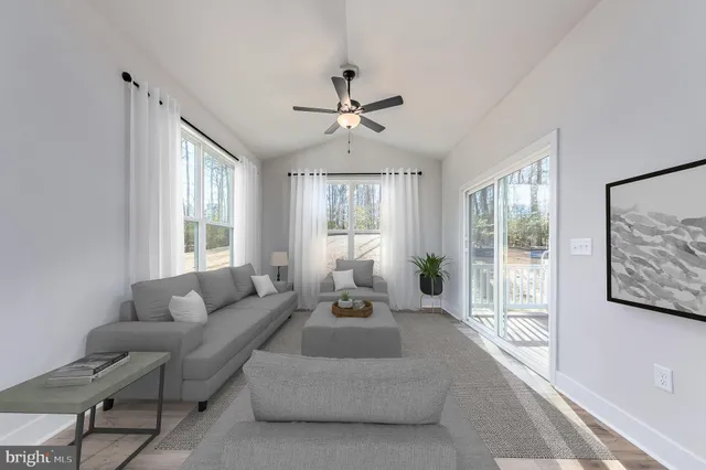 a living room with furniture large window and flat screen tv