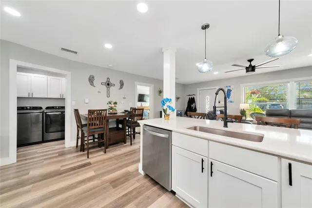 a kitchen with a dining table chairs and white cabinets
