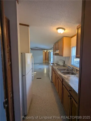 a kitchen with a stove a refrigerator and a sink