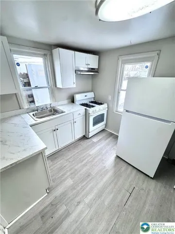 a kitchen with a stove a sink and a refrigerator