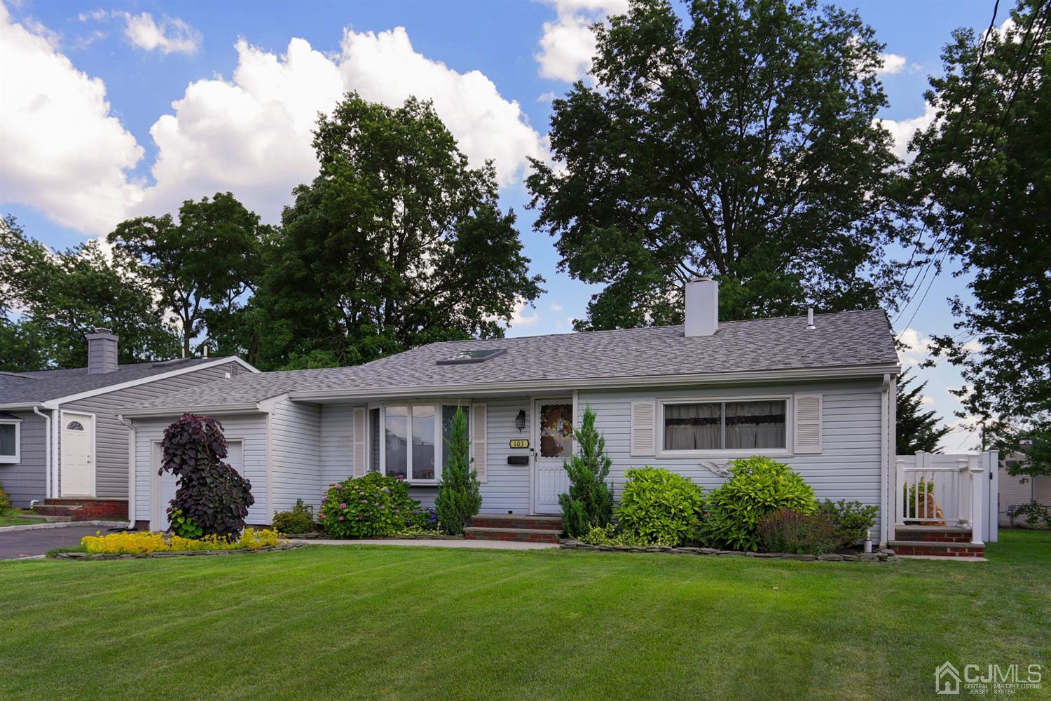 103 Westminster Road Colonia, NJ 07067 - Photo 3 of 26 a front view of a house with a garden and trees