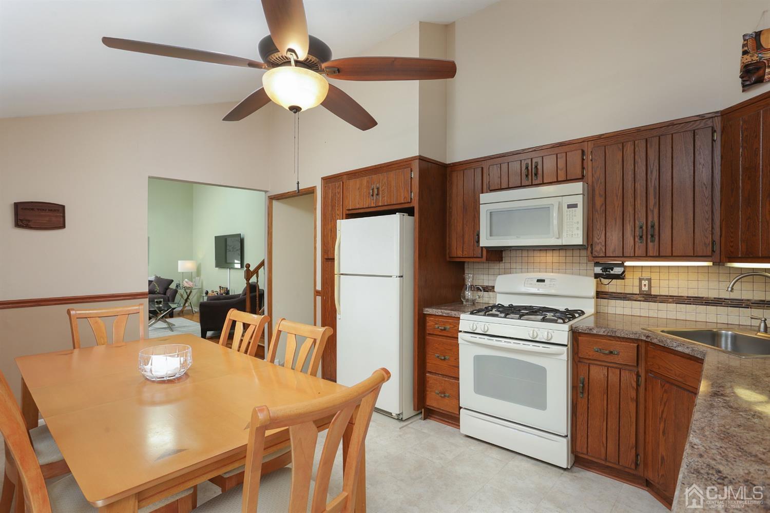 103 Westminster Road Colonia, NJ 07067 - Photo 10 of 26 a kitchen with a table chairs appliances and cabinets