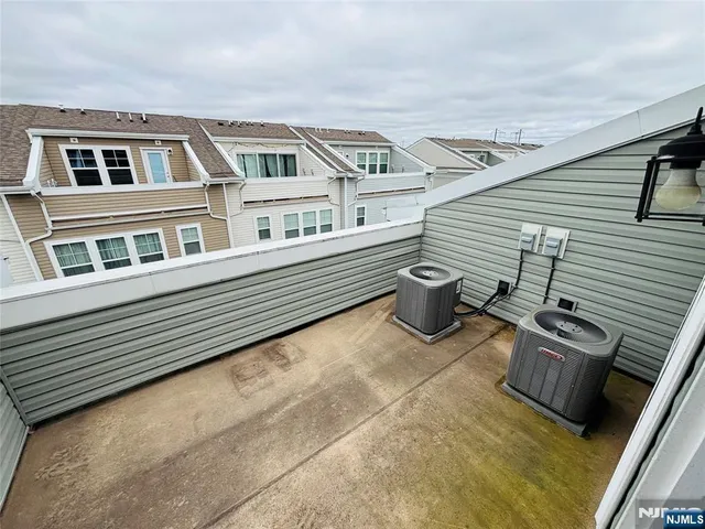 a view of a balcony with two chairs and a barbeque
