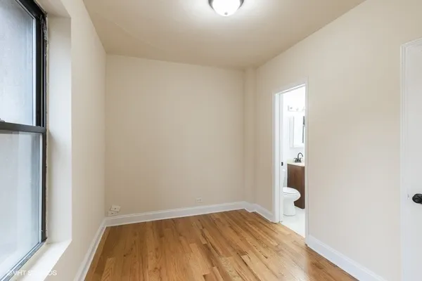 a view of a room with wooden floor and a window