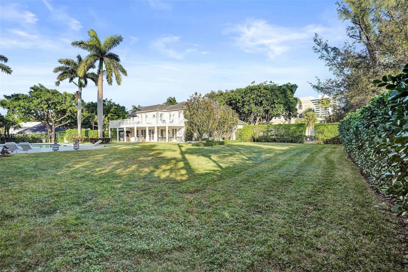 1281 Banyan Road Boca Raton, FL 33432 - Photo 17 of 69 a view of a swimming pool with a yard and palm trees
