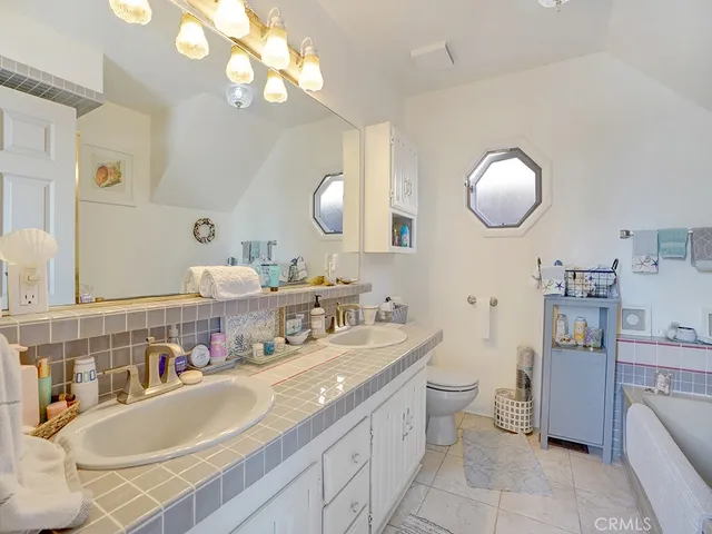 a bathroom with a granite countertop double vanity sink and a mirror