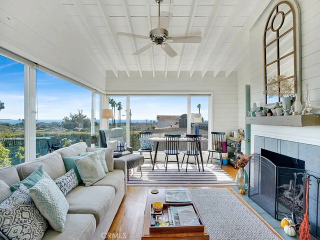 a living room with furniture a fireplace and a large window