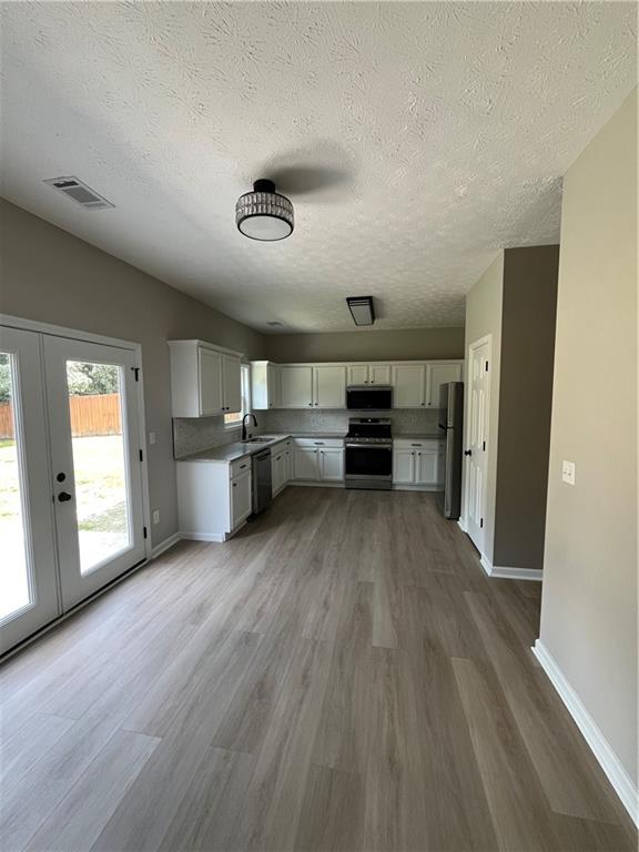 2147 St Albans Place Buford, GA 30519 - Photo 17 of 29 an empty room with wooden floor cabinet and windows