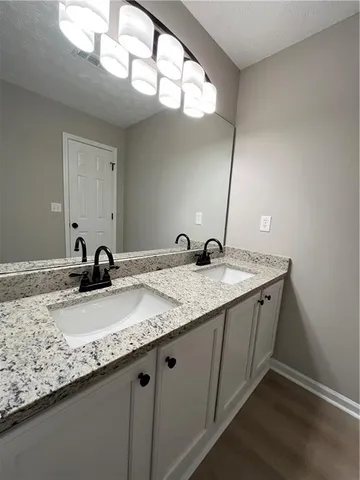 a bathroom with a granite countertop sink and a mirror