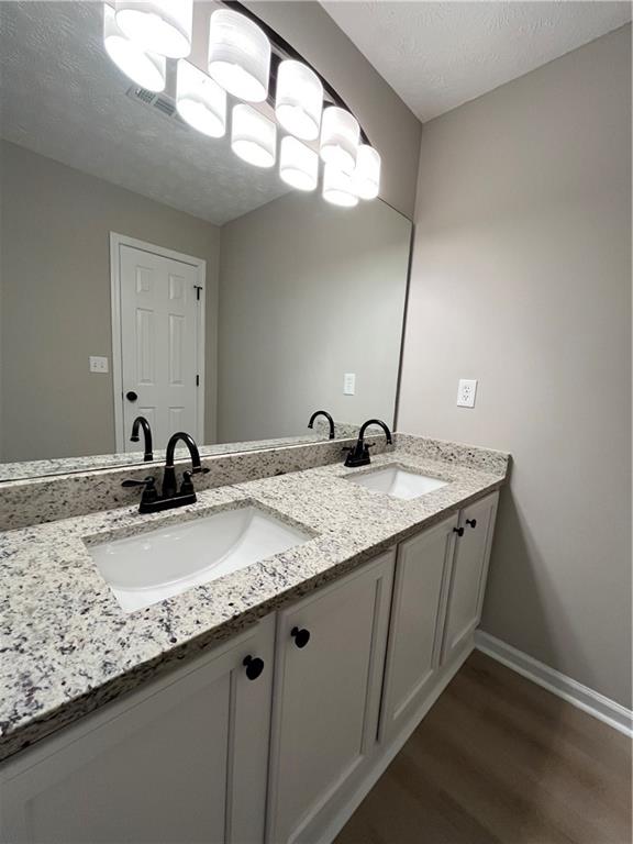 2147 St Albans Place Buford, GA 30519 - Photo 18 of 29 a bathroom with a granite countertop sink and a mirror