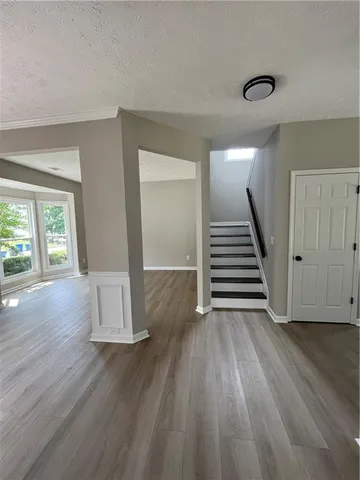a view of a livingroom with wooden floor and stairs