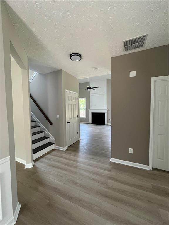 2147 St Albans Place Buford, GA 30519 - Photo 4 of 29 a view of an empty room with wooden floor and stairs
