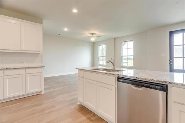 a kitchen with white cabinets stainless steel appliances and sink