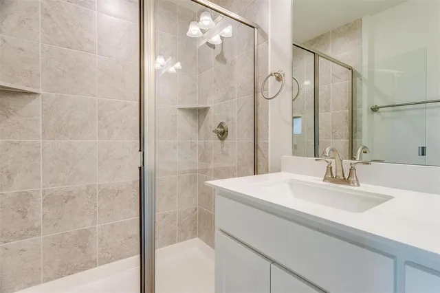 a bathroom with a sink shower and a mirror