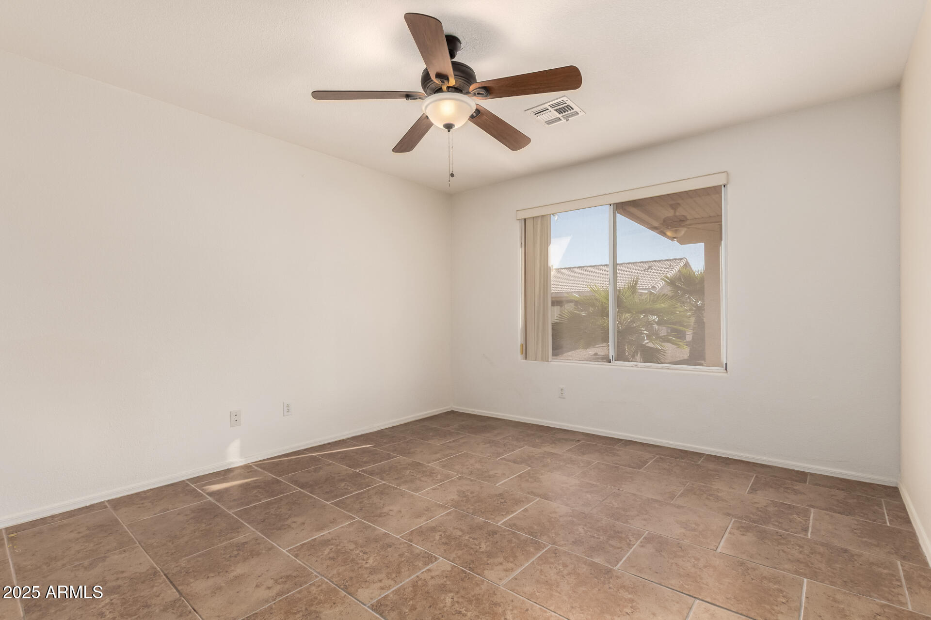1475 East Riviera Drive Chandler, AZ 85249 - Photo 10 of 22 an empty room with ceiling fan and windows