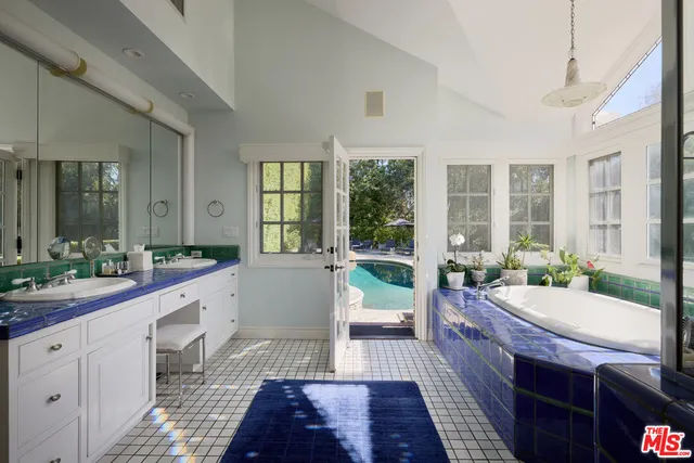 a large bathroom with a tub sink and mirror