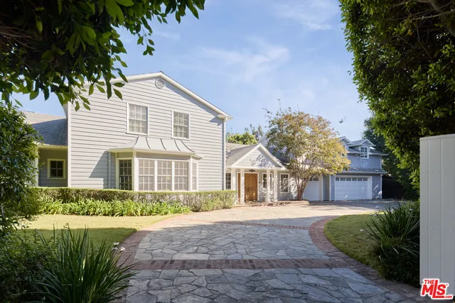 a front view of a house with a yard and potted plants