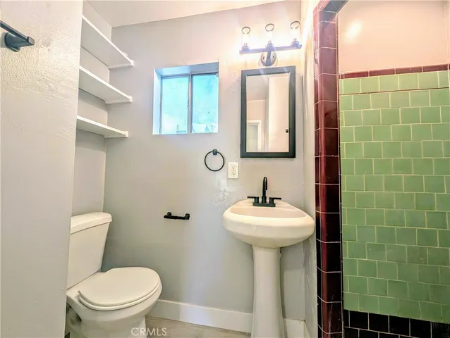 a bathroom with a sink toilet and a mirror