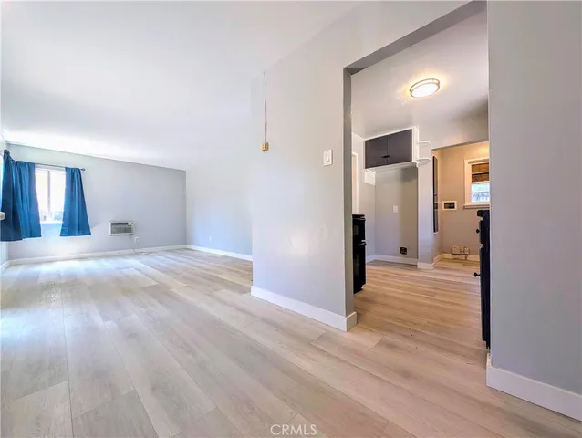 a view of a big room with wooden floor and a bathroom
