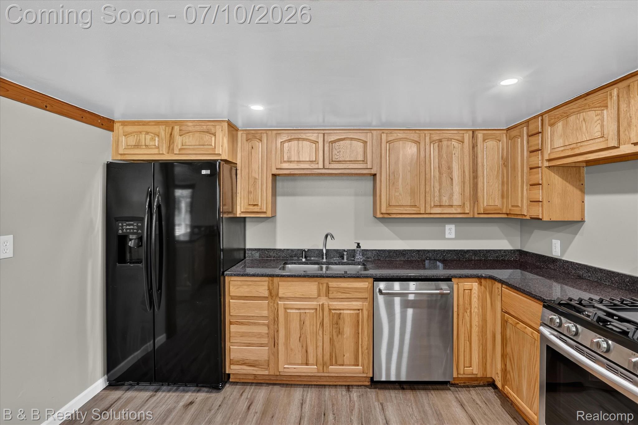 1564 East Burnside Road North Branch, MI 48461 - Photo 3 of 25 Kitchen featuring natural wood cabinetry, dark countertops, wood-finish flooring, stainless steel dishwasher, and a gas range