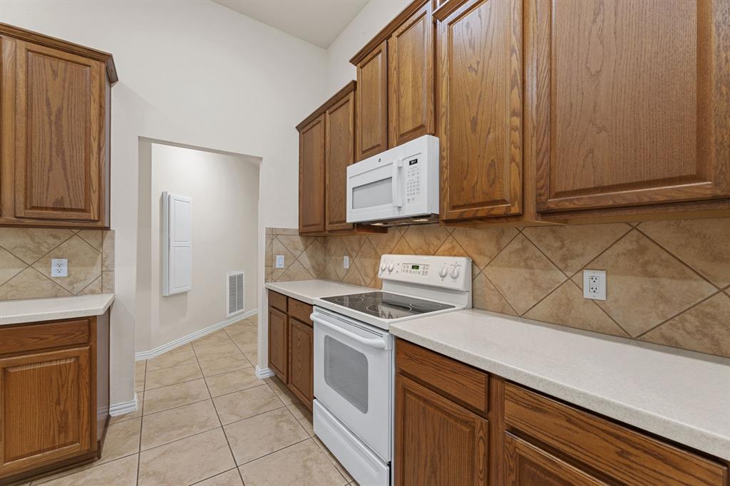 719 Scenic Ranch Circle Fairview, TX 75069 - Photo 12 of 36 a kitchen with a stove and a microwave