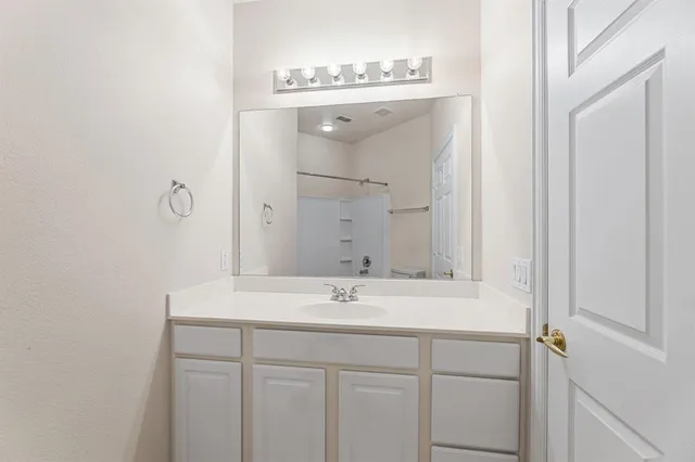 a white bath tub sitting next to a white toilet and vanity