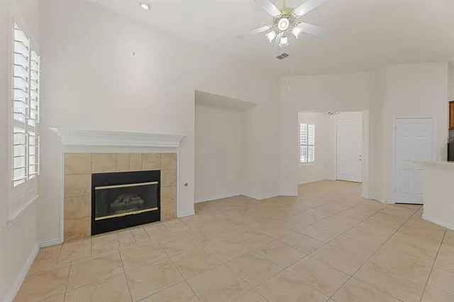 a view of empty room with fireplace and fan
