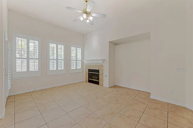 a view of an empty room with a fireplace and a window