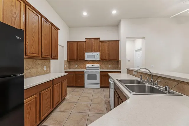 a kitchen that has a sink cabinets counter space and stainless steel appliances