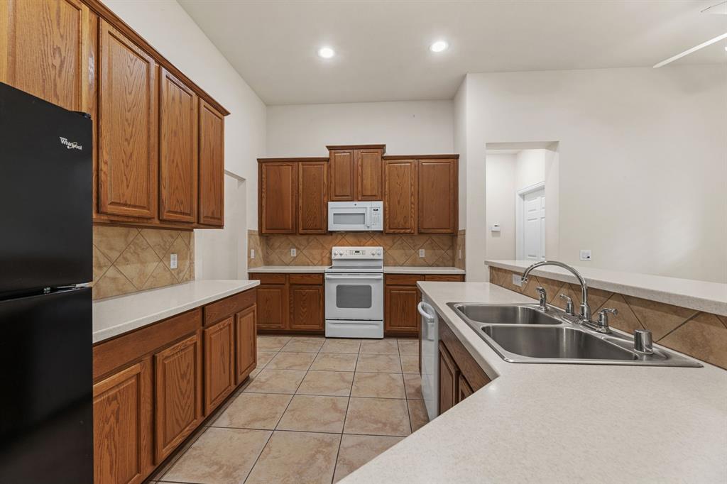 719 Scenic Ranch Circle Fairview, TX 75069 - Photo 10 of 36 a kitchen that has a sink cabinets counter space and stainless steel appliances