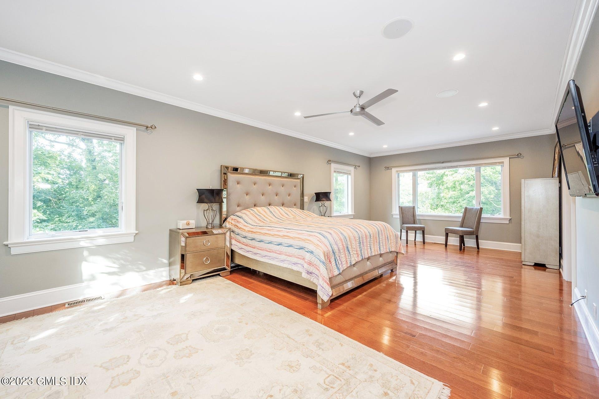 52 Hendrie Avenue Riverside, CT 06878 - Photo 14 of 30 a bedroom with a large bed a chandelier and a large window