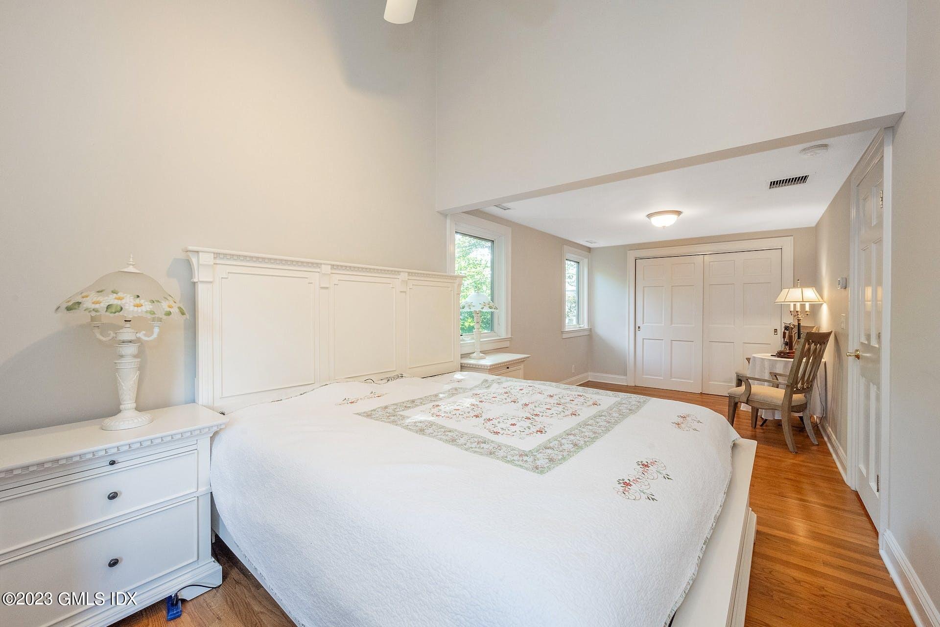52 Hendrie Avenue Riverside, CT 06878 - Photo 20 of 30 a spacious bedroom with a bed and a chandelier