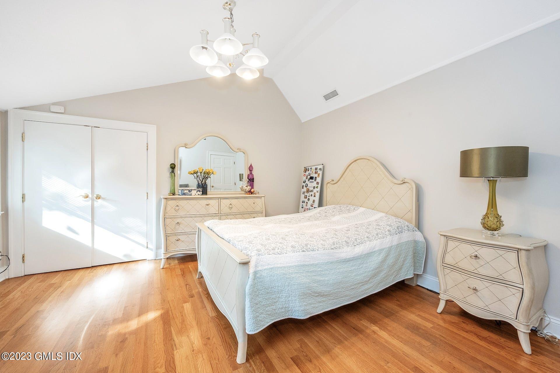 52 Hendrie Avenue Riverside, CT 06878 - Photo 21 of 30 a bedroom with a bed and a chandelier