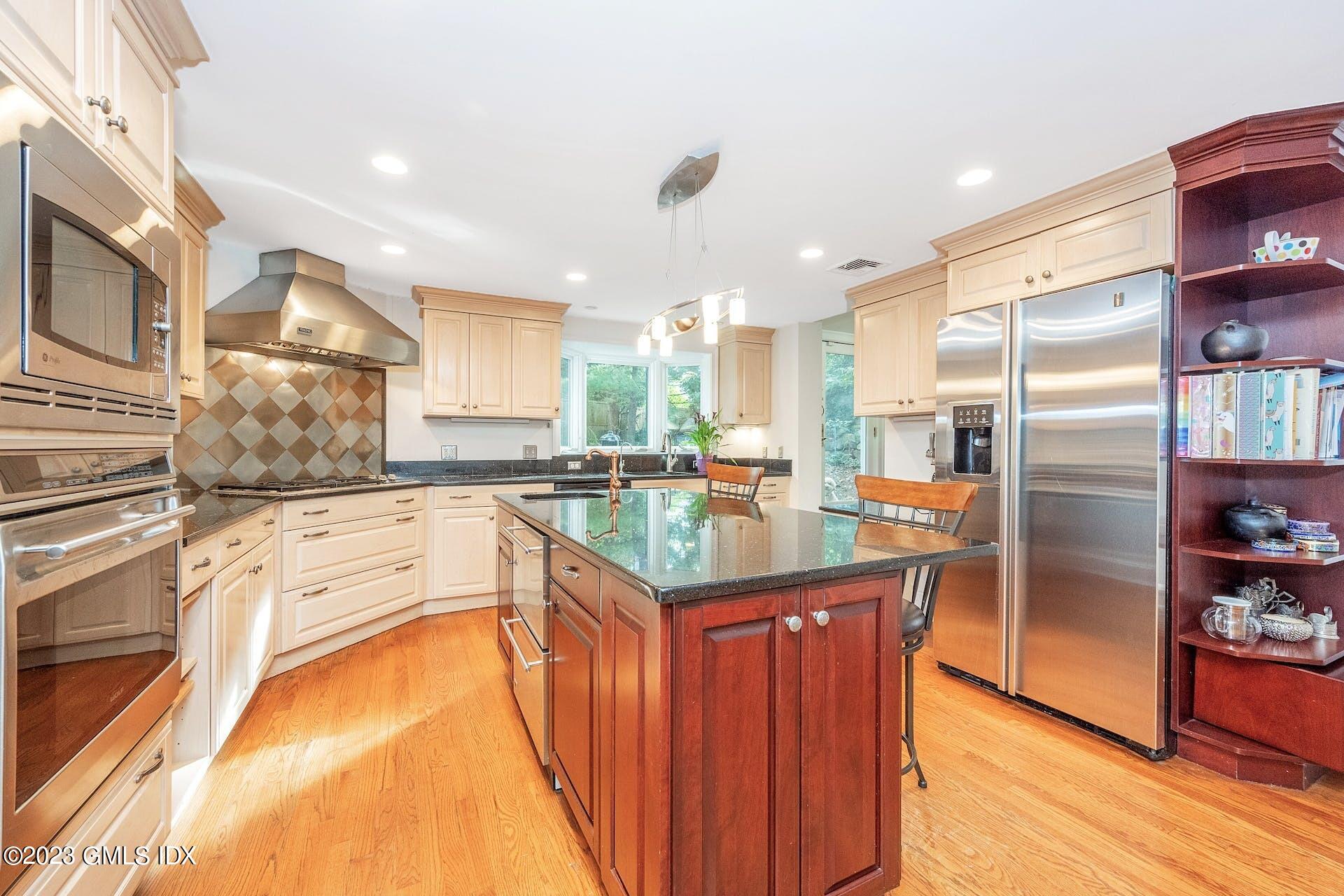 52 Hendrie Avenue Riverside, CT 06878 - Photo 7 of 30 a kitchen with stainless steel appliances granite countertop a refrigerator a stove and a wooden cabinets