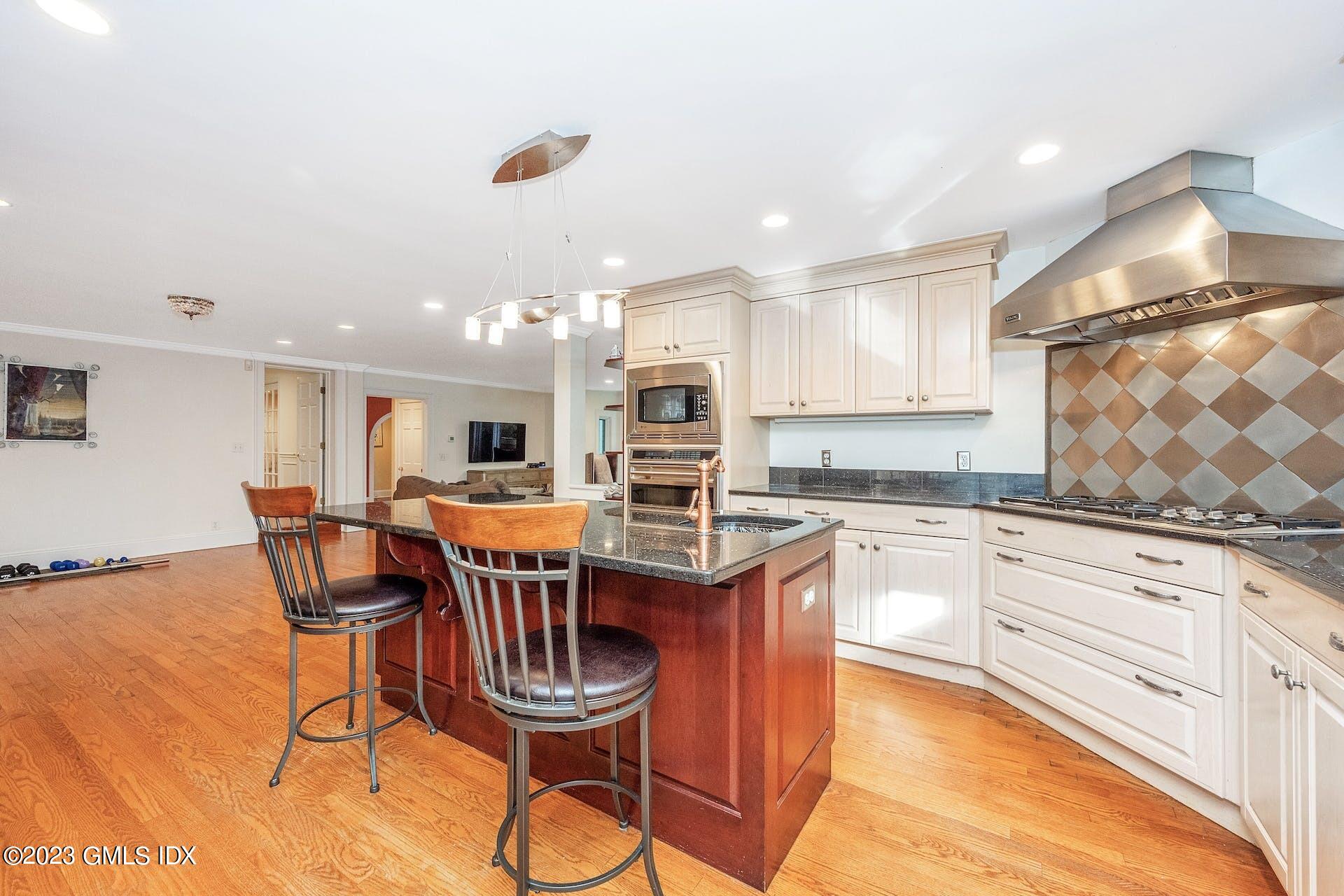 52 Hendrie Avenue Riverside, CT 06878 - Photo 8 of 30 a kitchen with stainless steel appliances granite countertop a dining table chairs stove a sink and dishwasher a refrigerator with wooden floor