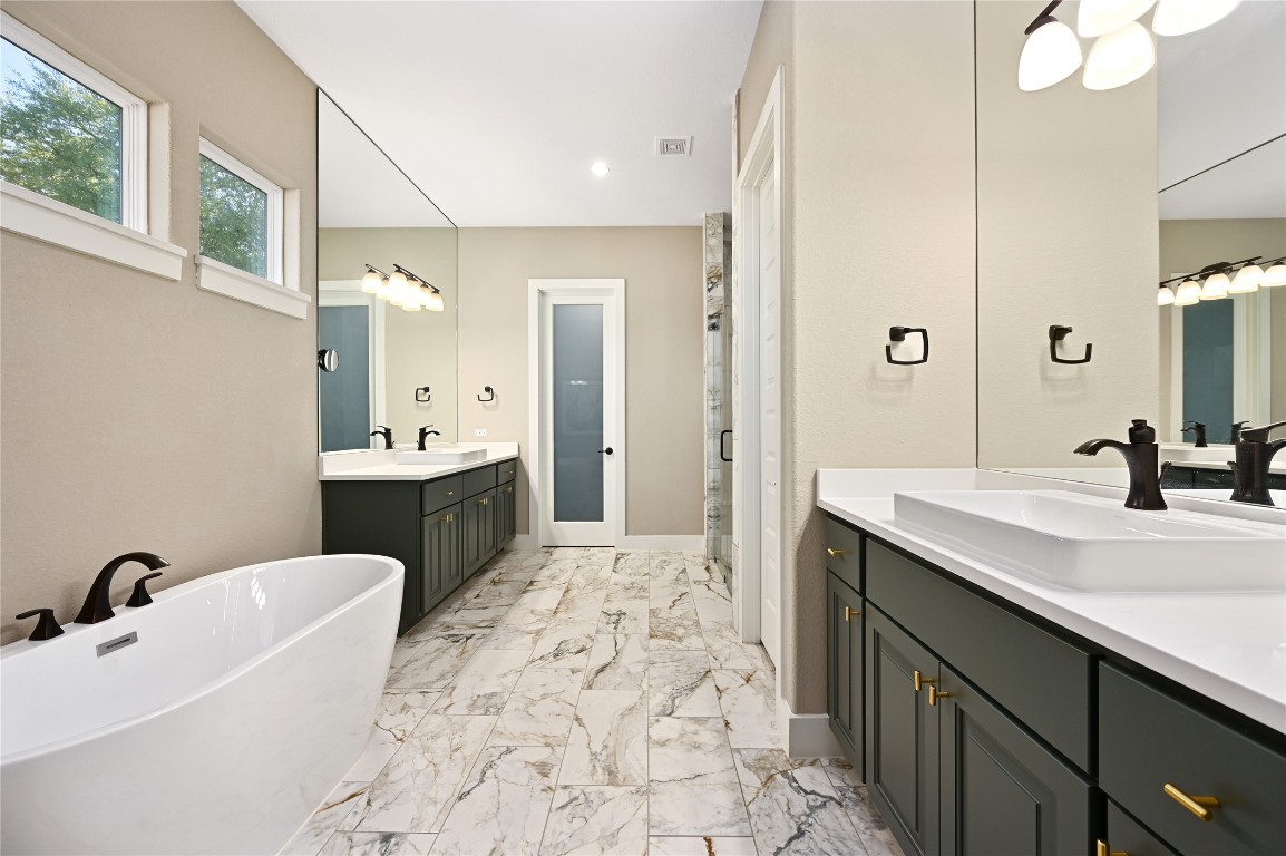 607 Flint Ridge Trail Georgetown, TX 78628 - Photo 12 of 35 Full bathroom featuring a freestanding tub, two vanities