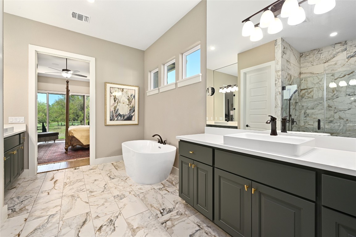607 Flint Ridge Trail Georgetown, TX 78628 - Photo 13 of 35 Ensuite bathroom with plenty of natural light, a marble finish shower, light marble finish flooring, and two vanities