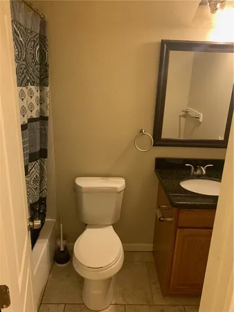 a bathroom with a toilet and a shower curtain