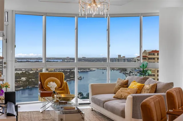 a living room with furniture a chandelier and a floor to ceiling window
